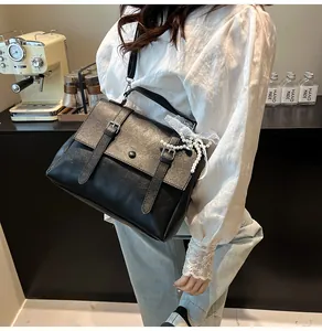 Dettaglio della borsa vintage nera con fiocco in pizzo e ciondoli di perle