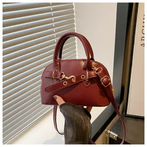 Detail shot of vintage dark burgundy mini shell bag with elegant gold hardware