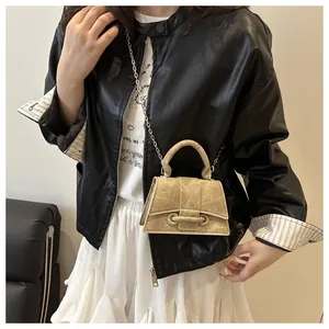 Primo piano dettagliato della mini borsa kaki con catena indossata da modella in pelle