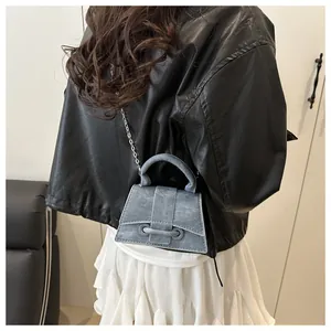 Vista dettagliata della borsa a trapezio in denim grigio con tracolla a catena sul modello