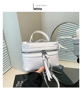 Detailansicht der weißen PU-Ledertasche mit Webmuster und langen Quastenreißverschlüssen