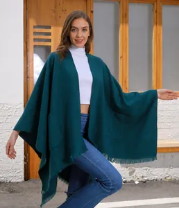 Detailansicht des dunkelgrünen Strickschals mit großen Taschen und Fransen