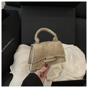 Dettaglio macro della mini borsa in tela lavata beige con catena in argento