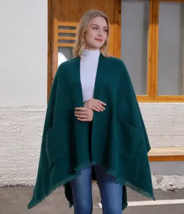 Detailansicht des dunkelgrünen Strickschals mit praktischen Taschen und Fransen
