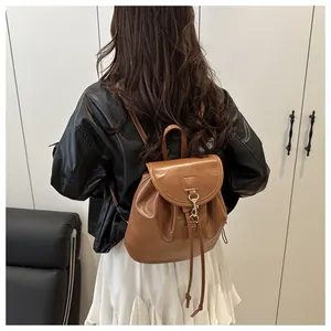 Détail du sac à dos en cuir caramel avec fermeture à cordon et boucle dorée chic