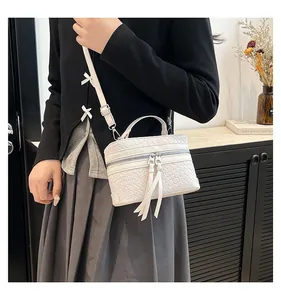 Détail du sac seau blanc tressé avec tirettes de fermeture éclair et poignée supérieure