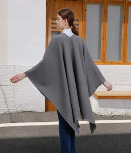 Rückansicht des langen dunkelgrauen Strickponchos mit Fransen und weichem Faltenwurf
