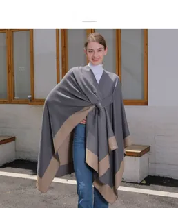 Outdoor shot of double-sided grey and khaki poncho cape paired with jeans