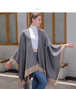 Detail of grey knitted shawl with camel contrast hem and a practical side pocket