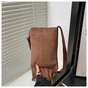 Mini bolso bandolera de ante marrón con flecos largos y detalles de costura cruzada