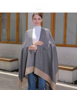 Detail of grey knitted shawl with brown patchwork hem and a functional front pocket