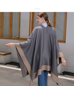 Rear view of a stylish grey and beige two-tone knit shawl with a flowy drape