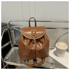 Vue détaillée d'un sac à dos en cuir marron avec crochet en métal et cordon de serrage