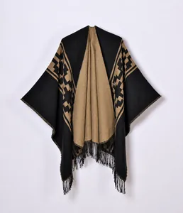 Detail eines Strickponchos mit geometrischem Muster und eleganten schwarzen Fransen