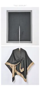 Close-up of color-block knit poncho wrap with belted waist and soft split-side design