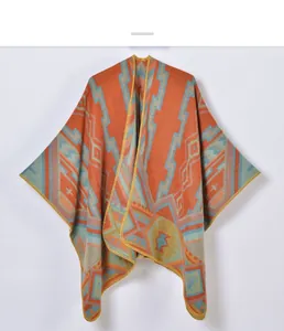 Detail of bohemian geometric knit poncho showing orange diamond patterns and texture