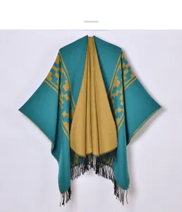Detail of knitted poncho featuring teal fabric with mustard yellow lining and black fringes