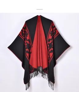 Detail of red and black geometric knit shawl with long fringe and jacquard pattern