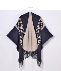 Detail of navy and beige knit shawl with ethnic geometric patterns and long black fringe