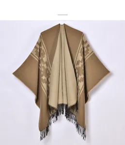 Detailed view of geometric jacquard knit shawl with elegant black hanging fringe accents