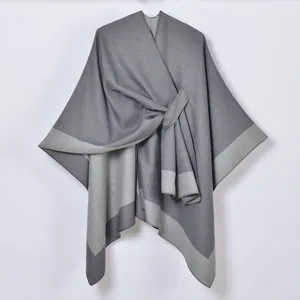 Detail of dark grey split shawl with light grey contrast edges and buckle closure