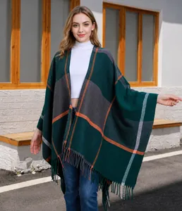 Detail eines dunkelgrünen Strickschals mit Karomuster und grauen Fransen am Saum