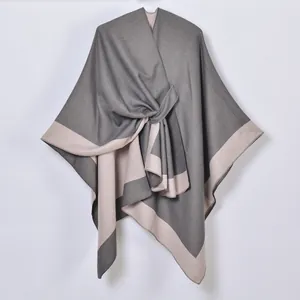 Detail of grey and beige color block shawl showing soft knit texture and edge stitching
