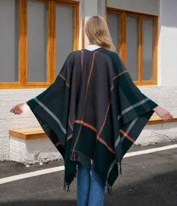 Detail eines dunkelgrünen Strickschals mit Karomuster, orangefarbenen Streifen und Fransen