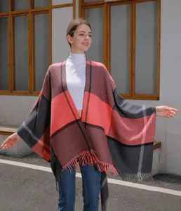 Detail eines rosa-grau karierten Strickschals mit Fransen an einem Model im Alltag