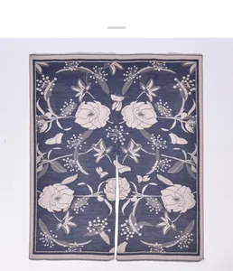 Dettaglio motivo jacquard con rose marroni e farfalle su scialle in maglia blu