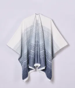 Detail view of high quality gradient blue stripes and short fringe on faux cashmere poncho
