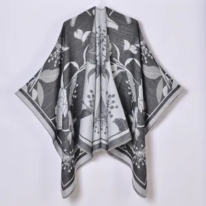 Dettaglio dello scialle in maglia stile pastorale con motivi jacquard di fiori e farfalle