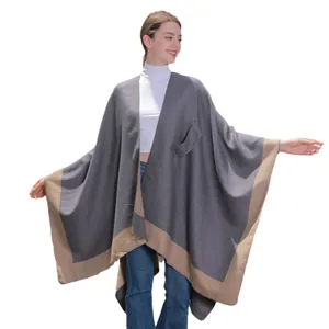 Grey knit split shawl cape with tan trim and a functional pocket for casual autumn wear
