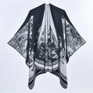 Dettaglio dello scialle in maglia jacquard bianco e nero con motivi etnici di paesaggi