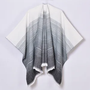 Close-up of fringe details and gradient striped texture on cashmere poncho shawl