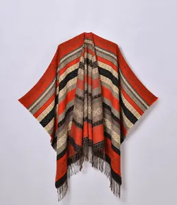 Close-up of geometric knit patterns and tassel fringe on a colorful travel poncho