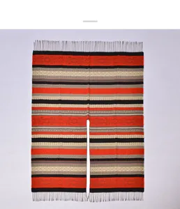 Close-up of ethnic striped shawl featuring red geometric patterns and fringe trim details