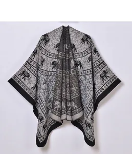 Close-up of ethnic elephant jacquard pattern on thick warm knit shawl with fringe edge