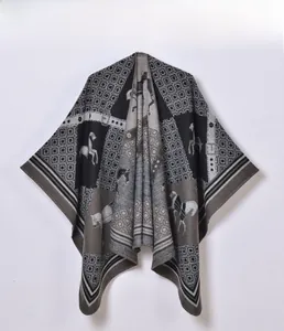 Detail view of woven knit poncho featuring horse silhouettes and geometric jacquard patterns