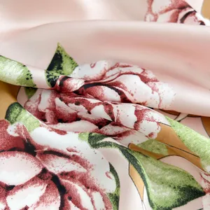 Texture dettagliata di un foulard in seta rosa con motivi a rose e finitura lucida