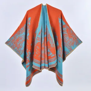 Dettaglio dello scialle in maglia con motivi a foglia arancio e blu e bordi rifiniti