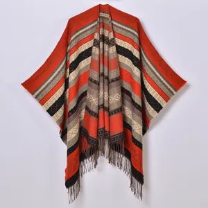 Ethnic style knit shawl poncho with geometric patterns and fringe tassels in warm colors