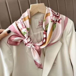 Elegante sciarpa in seta a fiori rosa abbinata a un abito beige per un look di classe