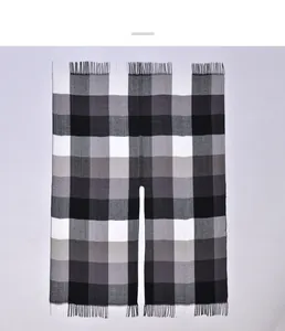 Detail of classic black and white plaid poncho shawl with fine fringe and split design