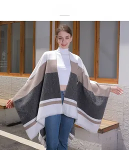 Close-up of tassel edges and knit texture on the striped color-block shawl cape