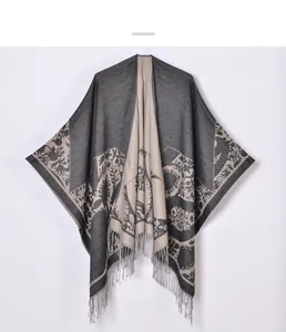 Detail of floral jacquard patterns and delicate grey tassels on bohemian shawl