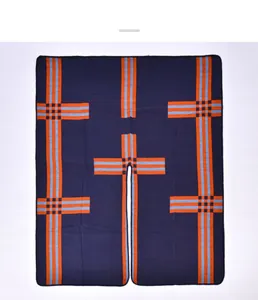 Détail du poncho en maille bleu marine à rayures orange et fente centrale sur fond blanc