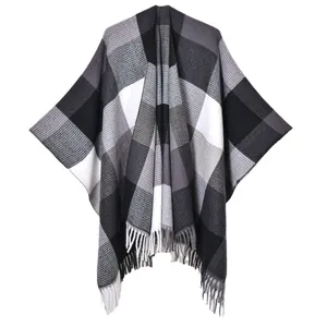 Classic plaid knit poncho with black, white, and grey check pattern and fringe tassels