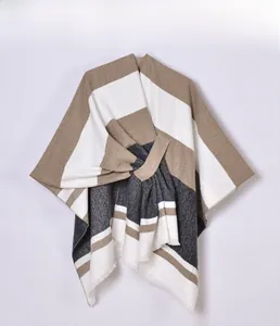Close-up of knit shawl with khaki, white, and dark grey stripes and tassel edges