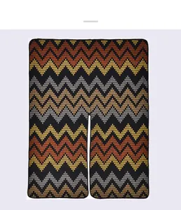 Detail of winter knitted poncho with zigzag geometric pattern in black and yellow